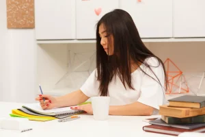 Asian brunette student writing her exercise or project