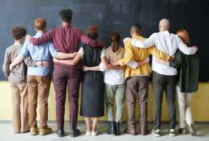 Group of people looking at black board while holing on each others