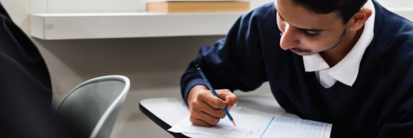 student writing with a pencil