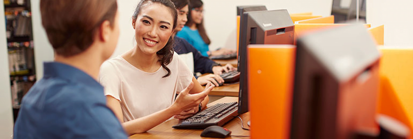 a woman smiling in front of computer